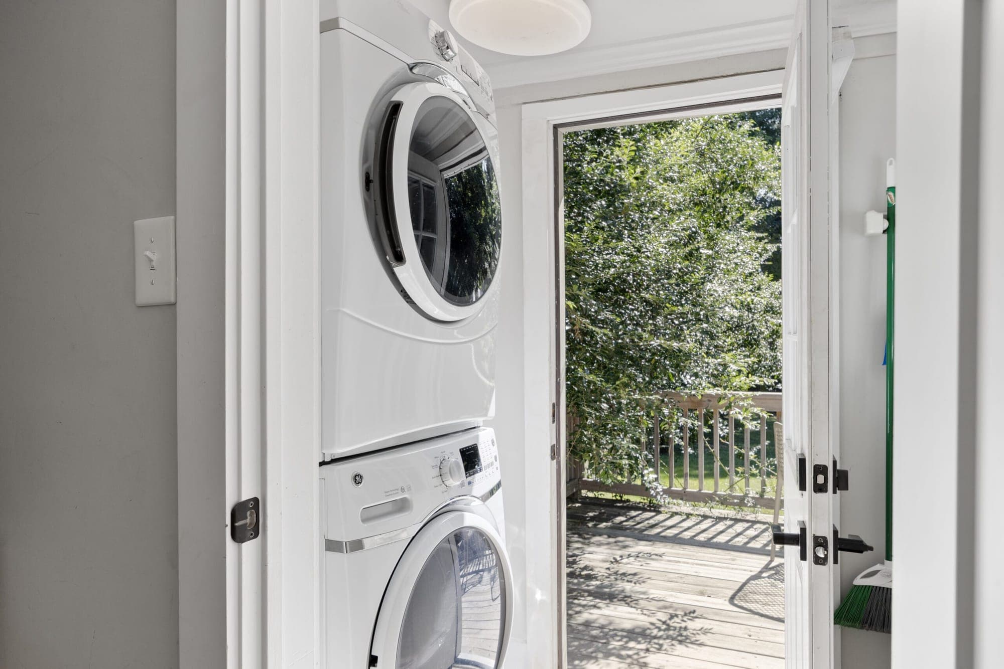 Stacked washer and dryer beside the door to the deck