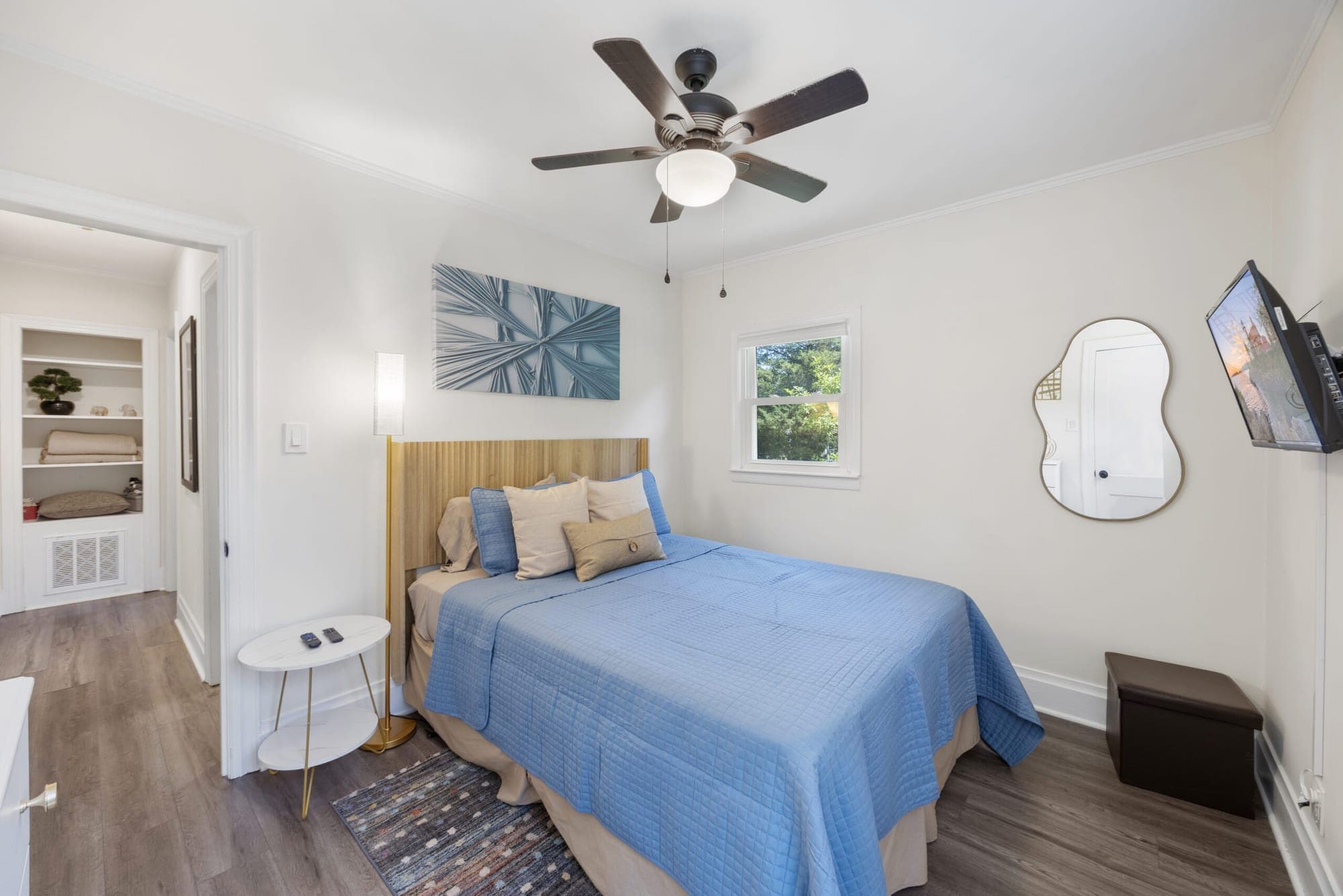 Bedroom with a blue bedspread and ceiling fan