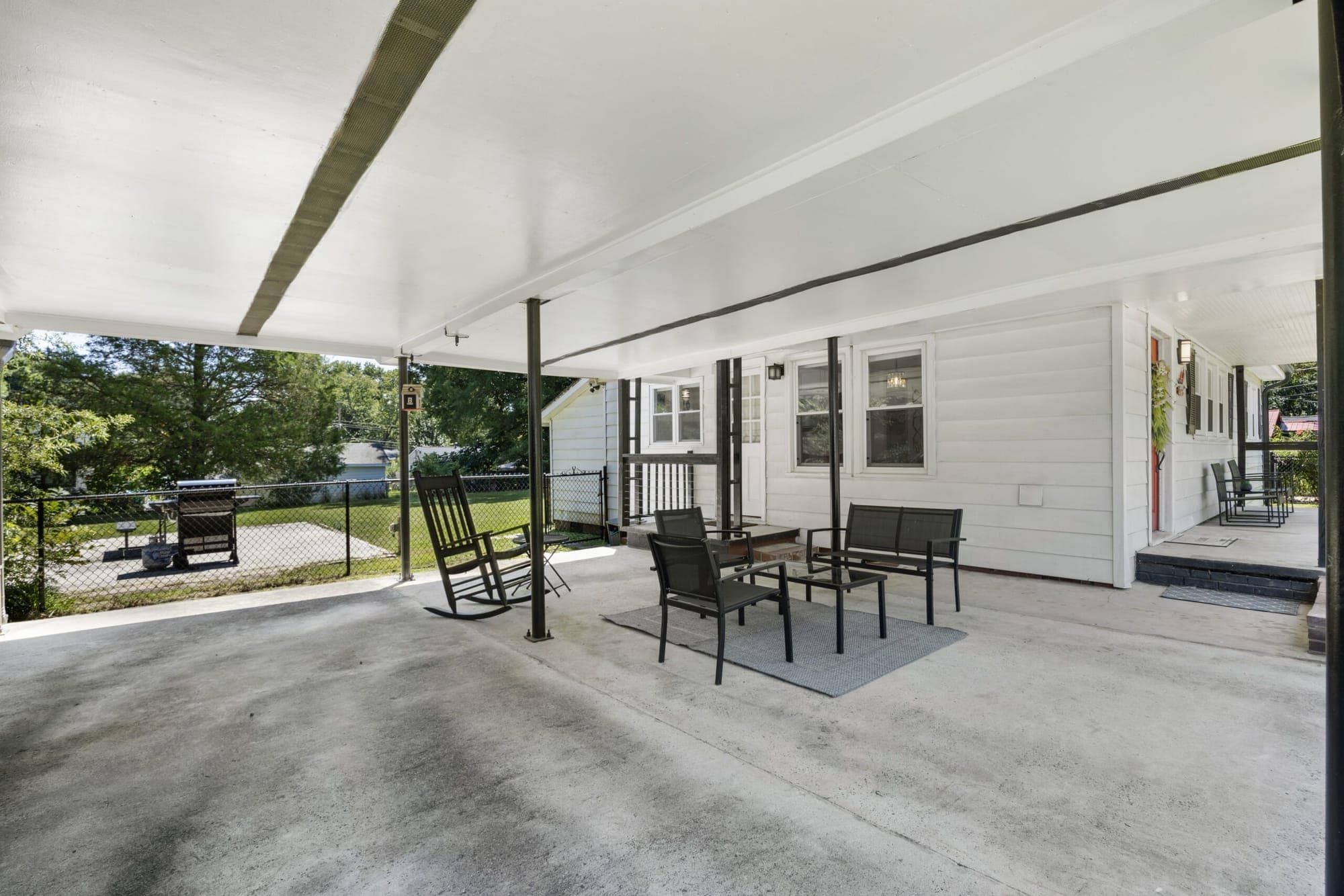 Covered patio with a rocking chair and bistro table