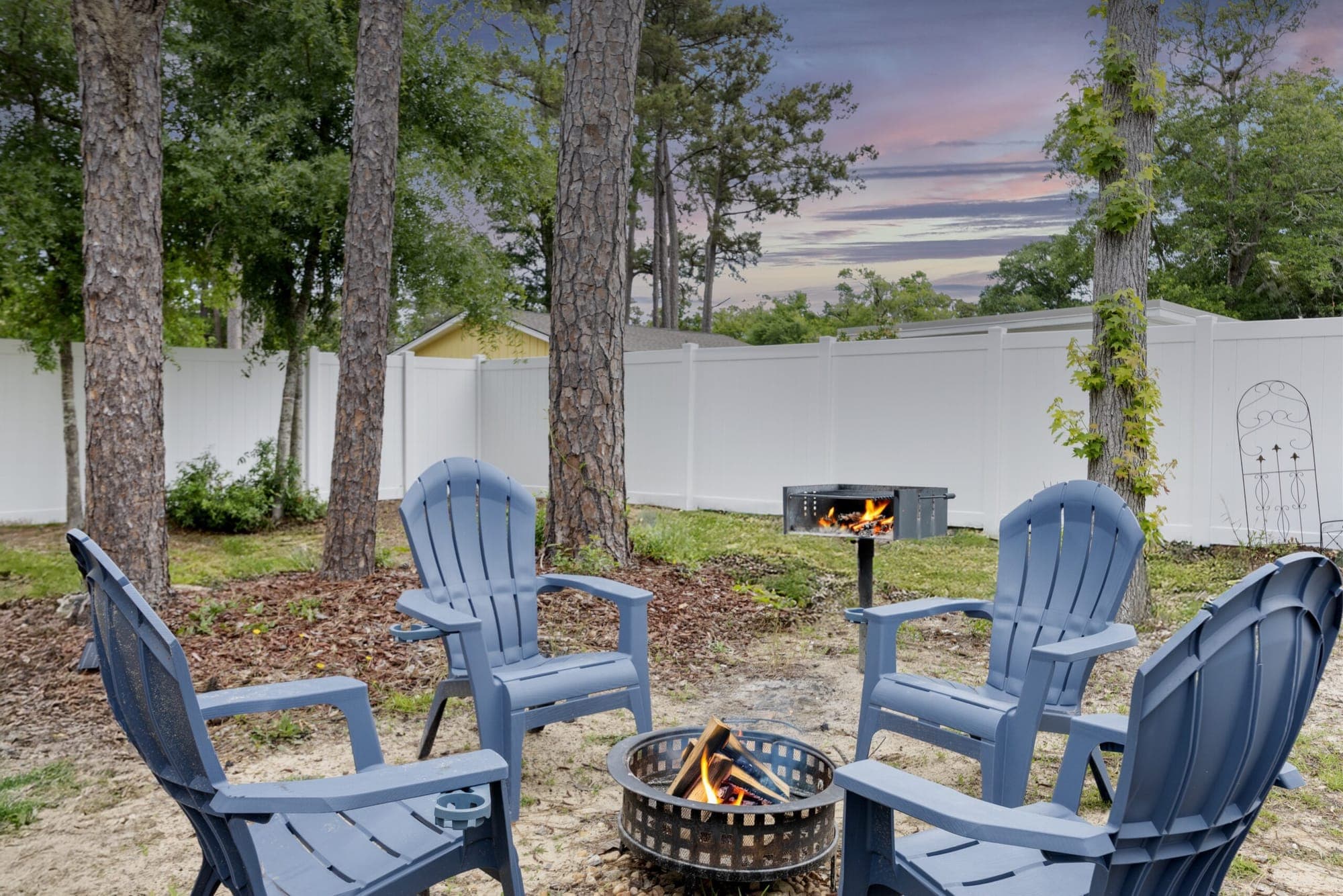 Backyard fire pit with Adirondack chairs at sunset