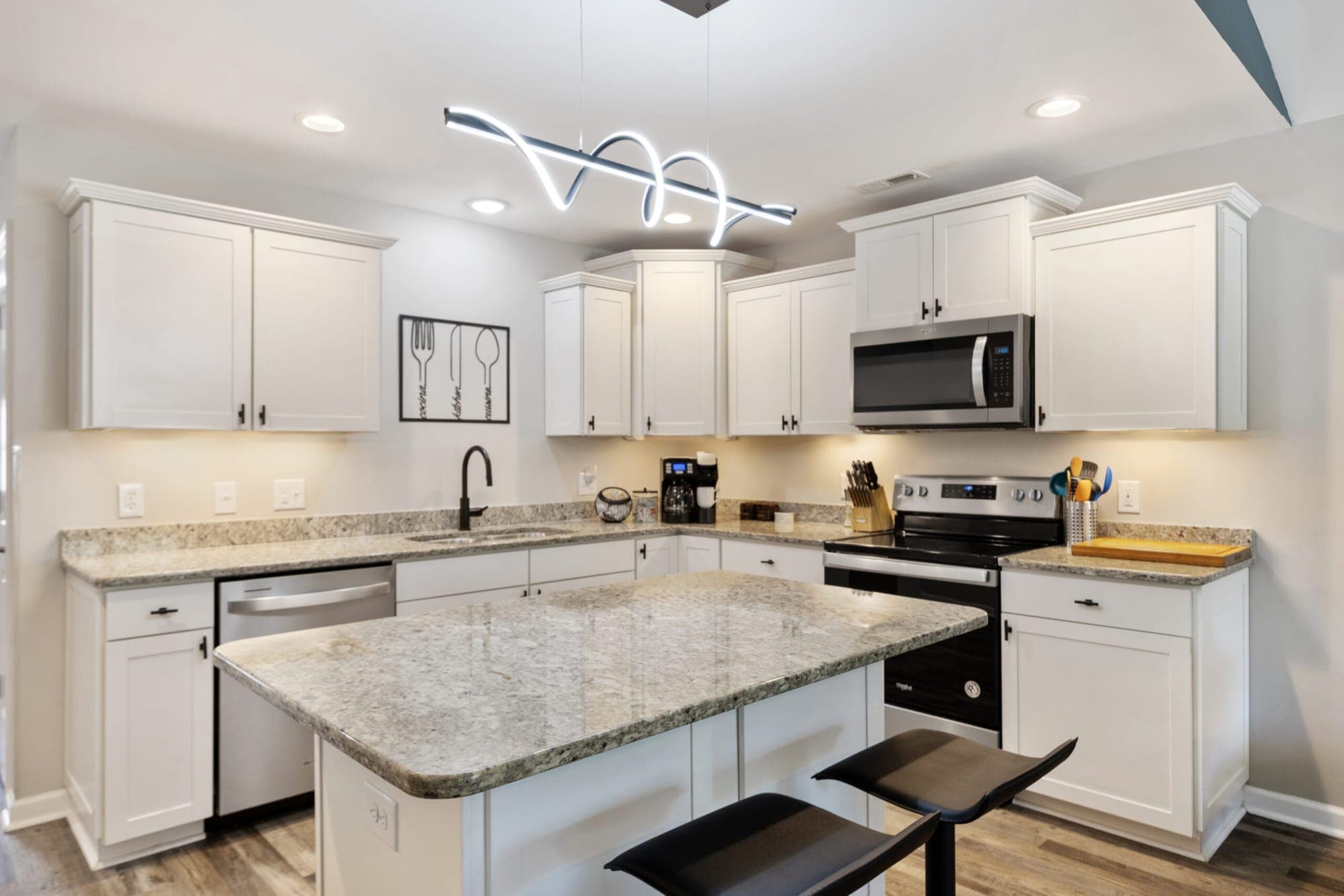 Kitchen with an island, white cabinets and granite counters
