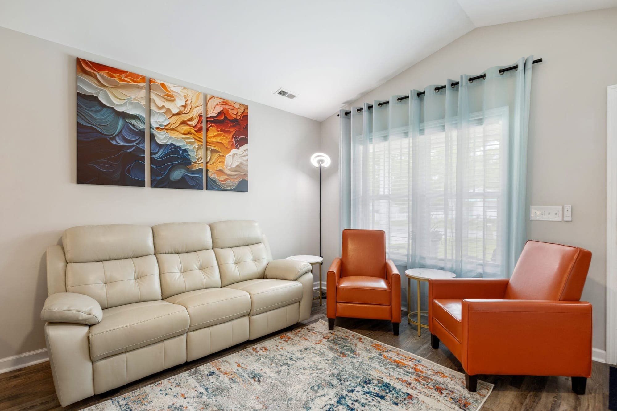 Living room with a cream leather sofa and orange armchairs