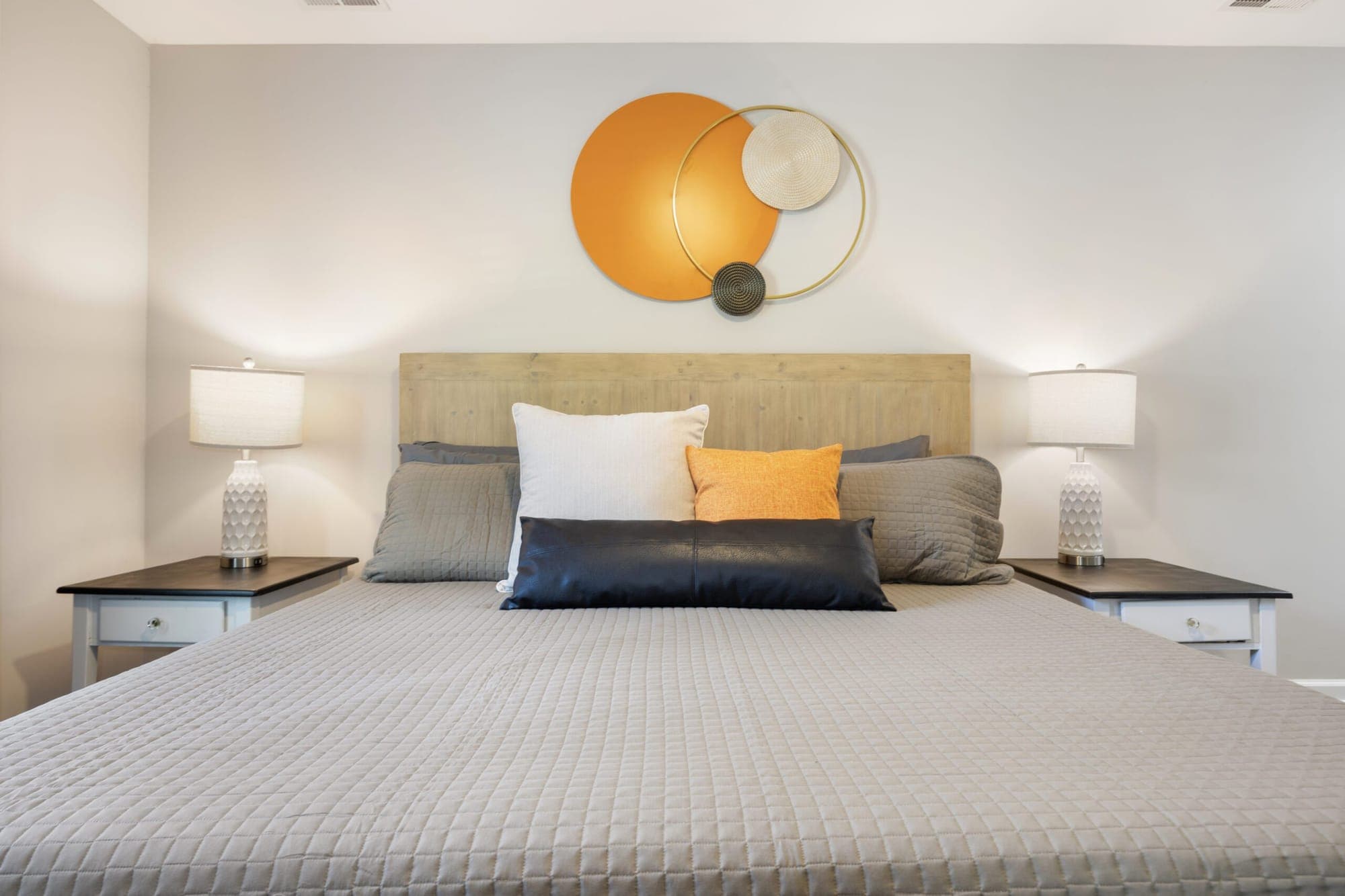 King bed with orange accent pillows
